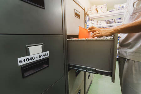 Office employee searching files in drawersの写真素材