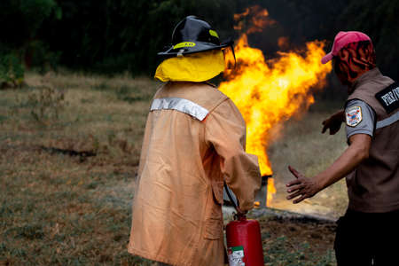 Firefighters are using fire extinguishers.