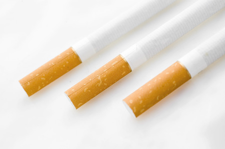 Three cigarets in line on white background.の写真素材