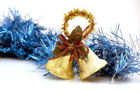 Two golden christmas bells on white background with blue decoration.