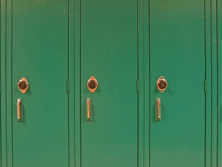 Three green school lockers with combination wheels; fairly close-up.の写真素材