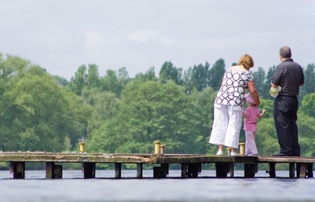 family on dock looking at lakeの写真素材