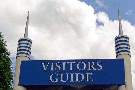 visitors guide sign with blue sky and clouds in backgroundの写真素材