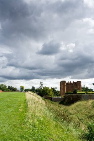 Castle moat with stormy clouds and castle ruinsの写真素材