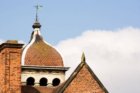close up of roof on old English mansion house with sky background