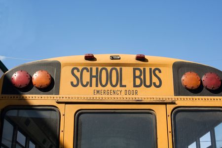 rear of yellow school bus covered in dust の写真素材