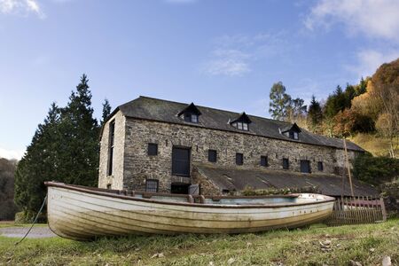 open boat in front of old warehouse on an autumn dayの写真素材