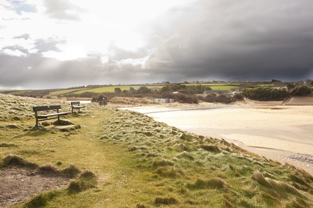 bright sunlight on a beach with approaching storm cloudsの写真素材