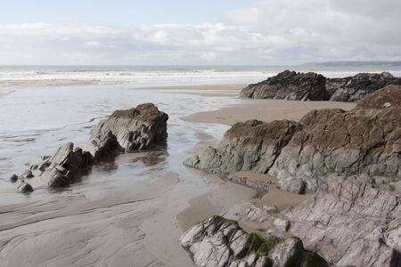 large rocks on a sandy beach in winter sunshine