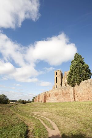 path through the grass along the side of castle wallの写真素材