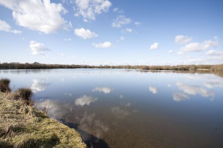 white cumulus clouds reflected in a lakeの写真素材
