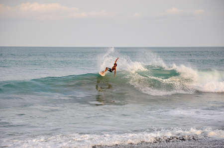 Jaco Beach, Pacific Coast, Costa Rica, March, 21, 2018: A surfer rides a wave at Jaco Beach, Costa...