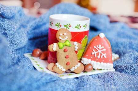Smiling gingerbread man and christmas red tea cup for christmasの写真素材