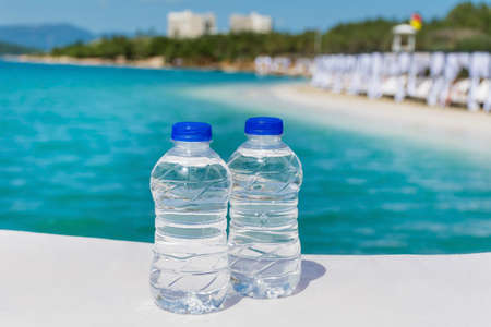 Two bottles mineral water on a sea background.Summer holiday conceptの写真素材