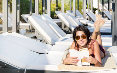 young beautiful woman relaxing and reading a book on the beach .Summer holidayの写真素材