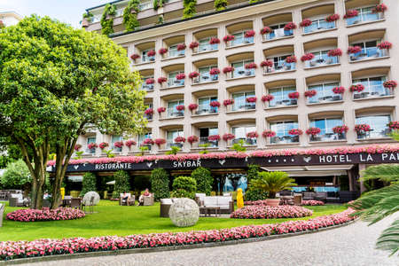 STRESA,LAKE MAGGIORE,ITALY-JUNE 25,2018 : Grand Hotel Des Iles Borromees with Windows with Geranium Flowers Blooming Abundantlyのeditorial素材
