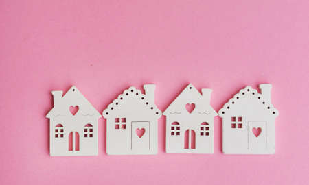 Wooden houses models on a pink background .Investing in real estate ,buying a houseの写真素材
