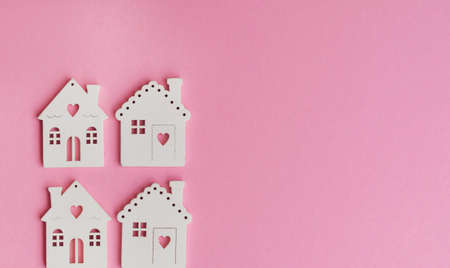 Wooden houses models on a pink background .Investing in real estate ,buying a houseの写真素材