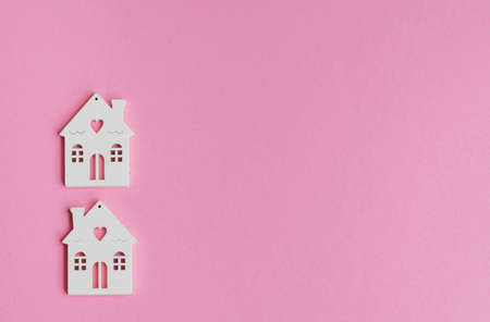 Wooden houses models on a pink background .Investing in real estate ,buying a houseの写真素材