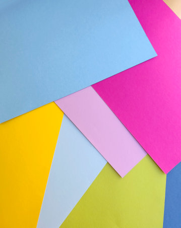 Colored paper background. Pink, yellow, blue and green.