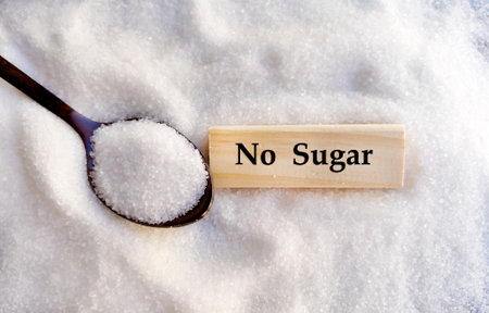 No sugar written on wooden block in spoon on pile of sugar backgroundの写真素材