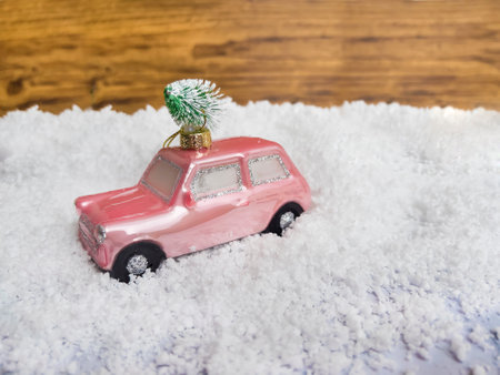 Christmas toy car with christmas tree in the snow on wooden backgroundの写真素材