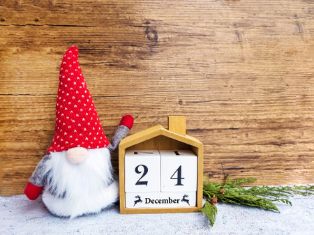 Wooden calendar with christmas gnome on a wooden background.の写真素材