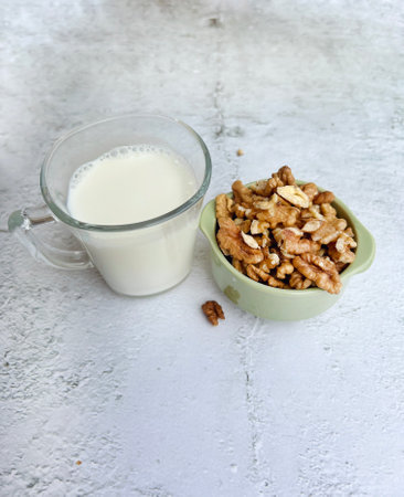Healthy breakfast with walnuts and a glass of milk on a white backgroundの写真素材