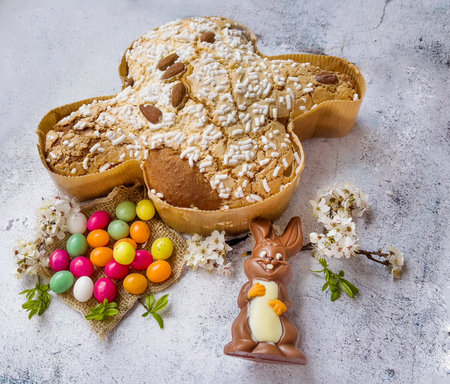 Easter gingerbread in the form of a rabbit, chocolate eggs and spring flowersの写真素材
