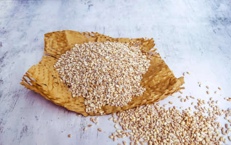 Whole wheat grains in a basket on a white wooden background.の写真素材