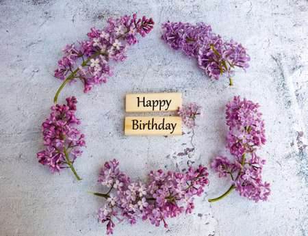 Lilac flowers and wooden sign with text Happy Birthday on concrete backgroundの写真素材