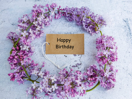 Happy Birthday card with lilac flowers on a rustic background.の写真素材