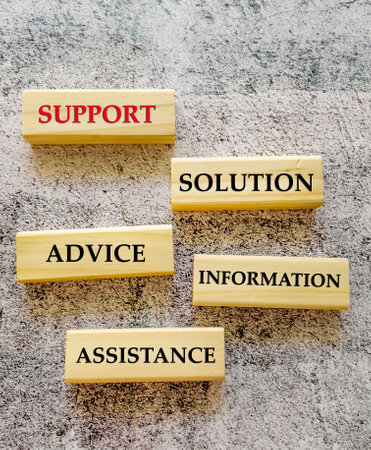 Support and assistance symbol. Wooden blocks with words support and assistance on cement backgroundの写真素材