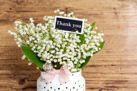 Bouquet of lily-of-the-valley (Convallaria majalis) on wooden backgroundの写真素材