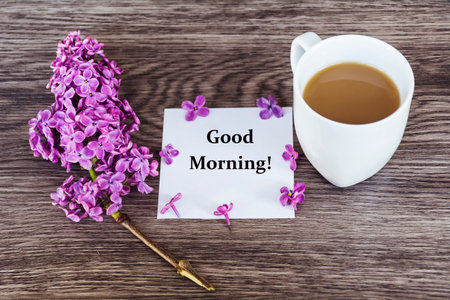 Cup of coffee, lilac flowers and card with text GOOD MORNINGの写真素材