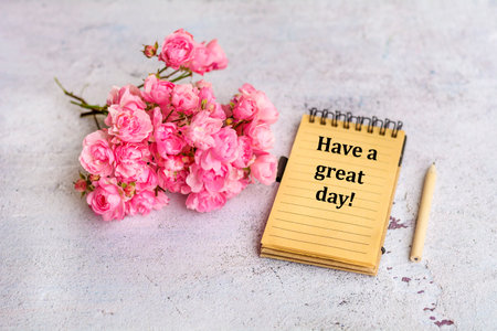 Bouquet of pink roses and notebook with textの写真素材