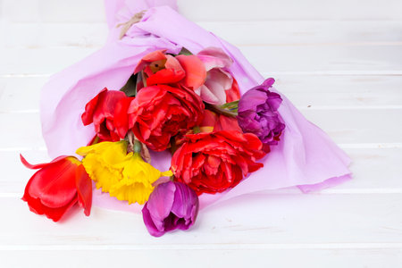 Bouquet of colorful flowers on a white wooden background.の写真素材