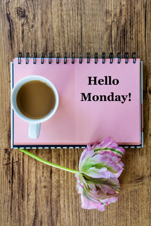 Hello Monday text on notepad with coffee cup and flower on wooden backgroundの写真素材