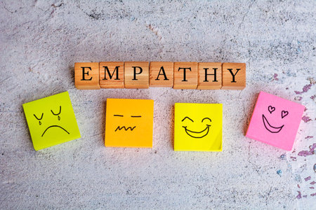 Empathy concept with smiley face on wooden cubes on concrete background