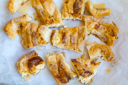 Homemade apple strudel with cinnamon and sugar on baking paperの写真素材