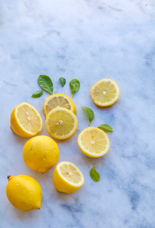 Lemons and lemons with green leaves on a marble backgroundの写真素材