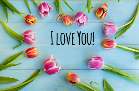 Inscription I LOVE YOU with pink tulips on blue wooden backgroundの写真素材