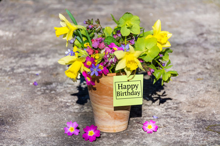 Bouquet of spring flowers in wooden vase with tagの写真素材