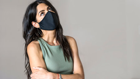 Portrait of a woman wearing a face mask with arms crossed.の写真素材