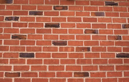 a red and dark brown brick wall on a 80 year old house with klinker bricks