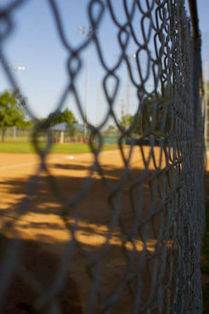 a short depth of field photo of chain link fence around a baseball fieldの写真素材
