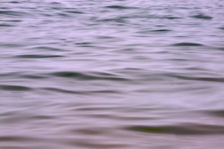 Blue brown light wave action on the surface of lake Michigan on a calm day