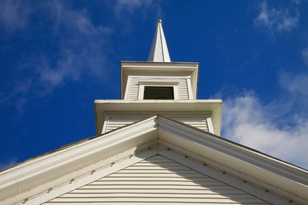 Old Church steeple against a blue sky with white cloudsの写真素材