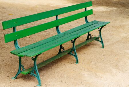 Empty green wood park bench on gravel の写真素材