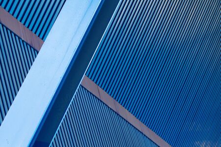 Disorienting convergence of corrugate blue steel cieling, wall, and beamの写真素材